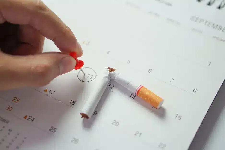 Start der Nichtraucher-Challenge: Zerbrochene Zigarette auf Kalender markiert den Beginn des Rauchstopps