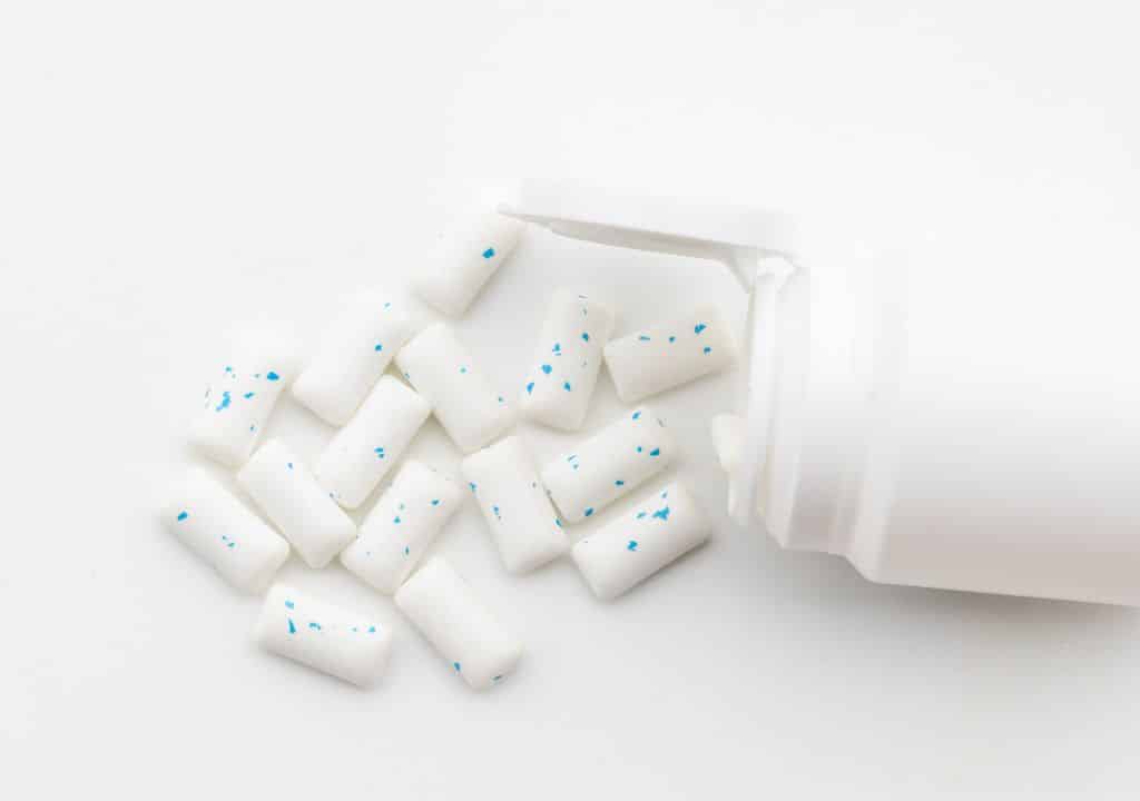 Nikotinkaugummi als Nikotinersatzprodukt beim Rauchstopp auf weißem Hintergrund