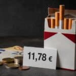 Geöffnete Zigarettenpackung neben Euro-Scheinen, Münzen und einem Preisschild mit 11,78 Euro